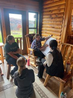 Participants in small breakout group talk during the 2025 Rural Health Scholars Retreat