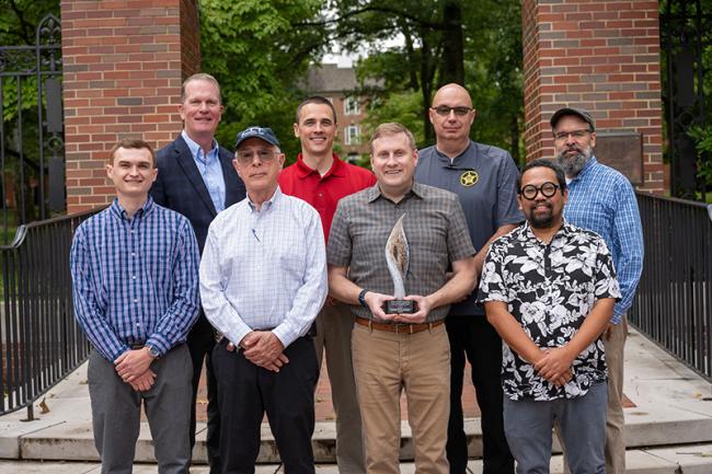 Winners of the 2023 FBI National Academy Associates Science and Innovation Award stand with the award in front of Schoonover