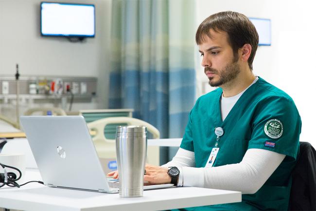 An Ohio University nurse practitioner student working at their laptop