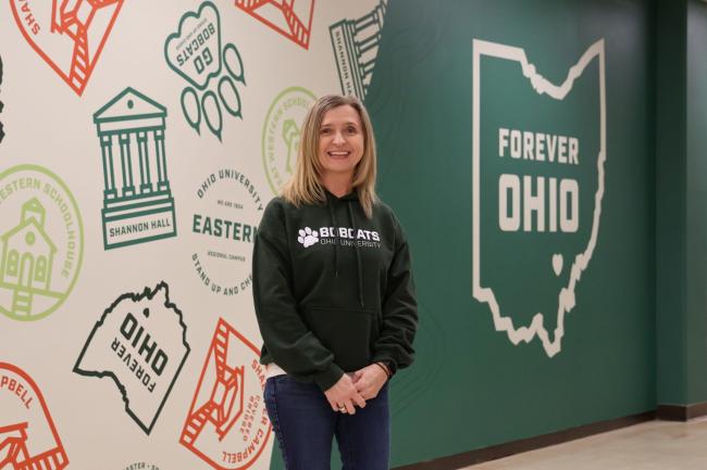 Women with blond hair wearing a green crew neck sweatshirt