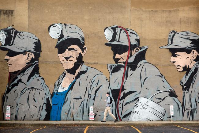 A mural depicting four coal miners on the side of a building in uptown Athens Ohio