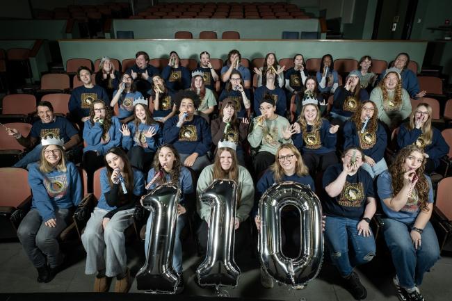 Staff members are shown in the seats at the Athena Cinema holding the numbers 1-1-0 and wearing party hats and blowing party horns