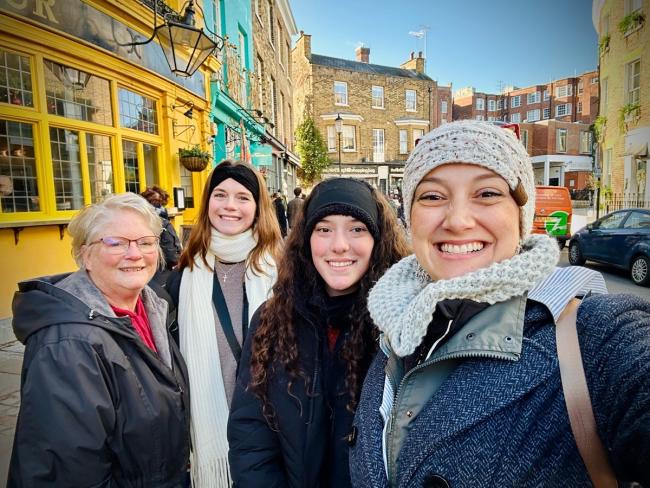 OHIO students and faculty member Teri Peasley stand together on a busy sidewalk in England