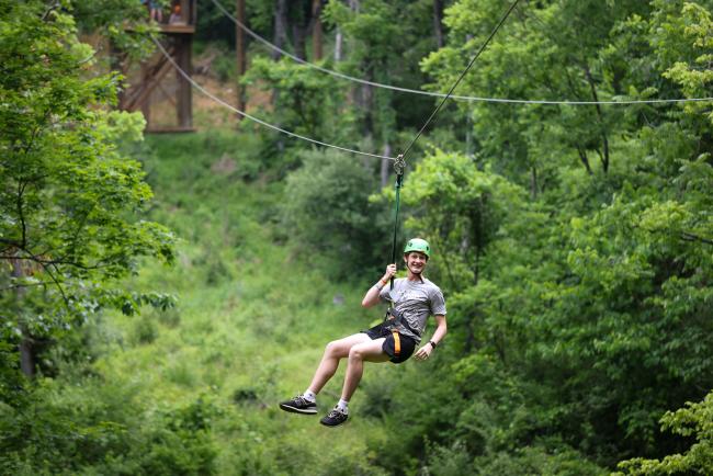 Cat Camp participant swings on zipline