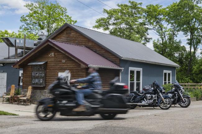A motorcyclist rides past Triple Nickel Diner during lunch service in Chesterhill, Ohio. 