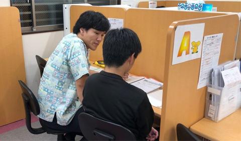 Nakada helping a student at their desk