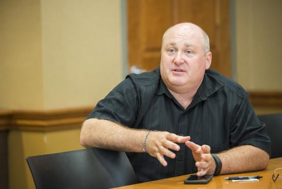  Photo of Geoff Dabelko sitting in a conference room 