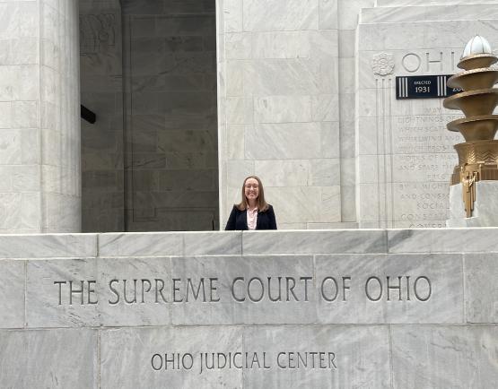  Kirsten Thomas poses behind a marble wall that reads &amp;quot;Supreme Court of Ohio&amp;quot; with below it &amp;quot;Ohio Judicial Center&amp;quot;&quot; loading=&quot;lazy 