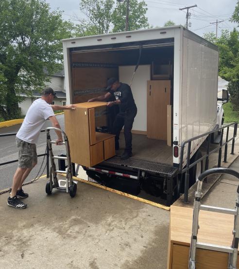 Moving and Surplus staff load furniture into a moving truck
