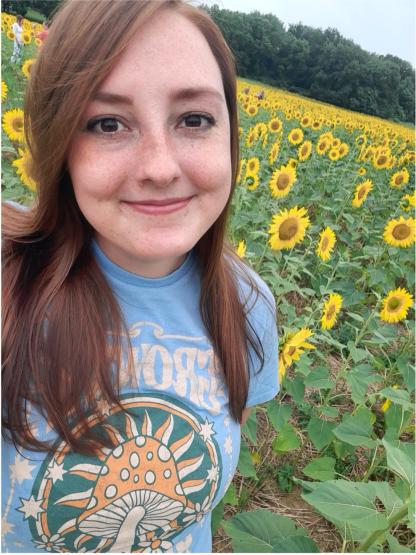 Sydney Dawes standing in front of a field of wildflowers