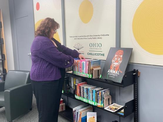  Emma Adams browses the community collection at Quinn Library 