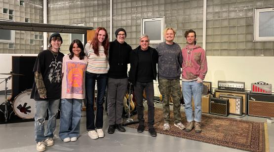  A group of students pose for a photo in a large music studio 