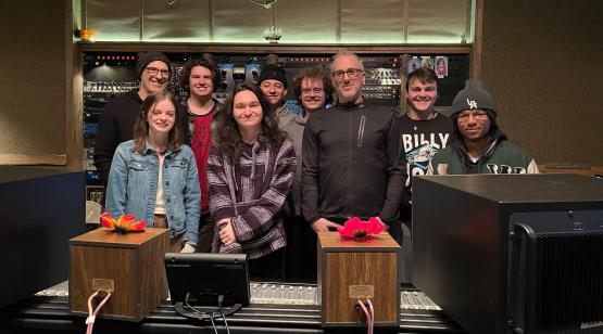  A group of students pose for a photo in a music studio 