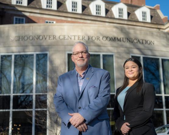 Dean Scott Titsworth poses with sophomore Bella Moyers-Chavez in front of the Schoonover Center for Communication 