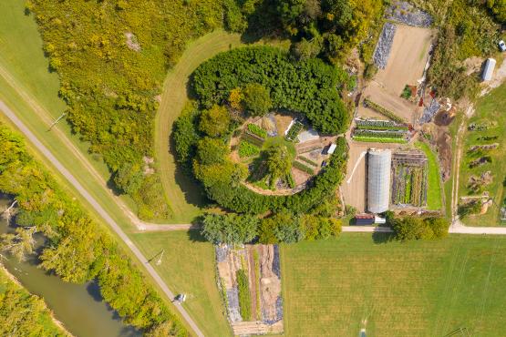  An aerial view from a drone looking down at the student farm. The circular learning garden, USDA-certified organic plots and more are visible. 