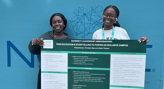  Student pose with their presentation at conference 