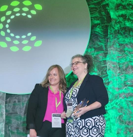 Heather Krugman holds an award at the annual conference in Indianapolis