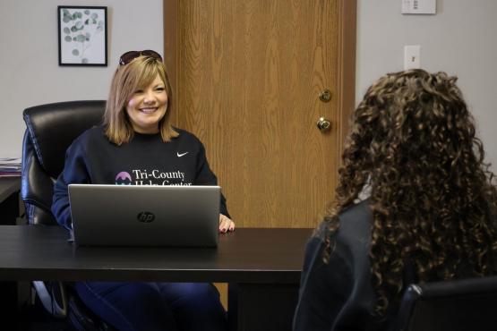  Female smiling sitting at a desk behind a computer 