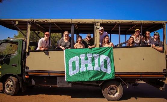  group of people posing in a safari van holding a OHIO flag 