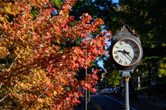 Colorful fall leaves surround a clock on OHIO&amp;#039;s Athens campus