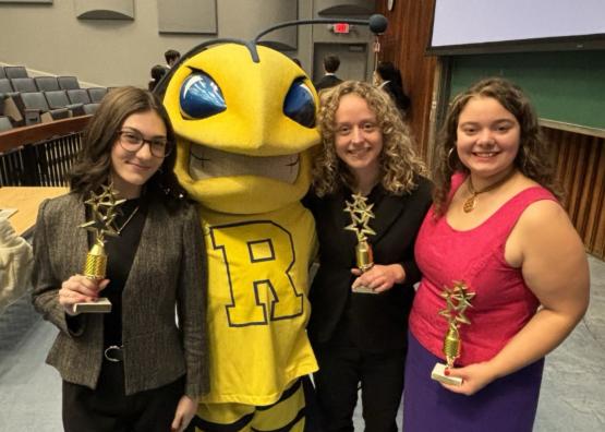  Three students pose with the Rochester mascot, a yellow bee 