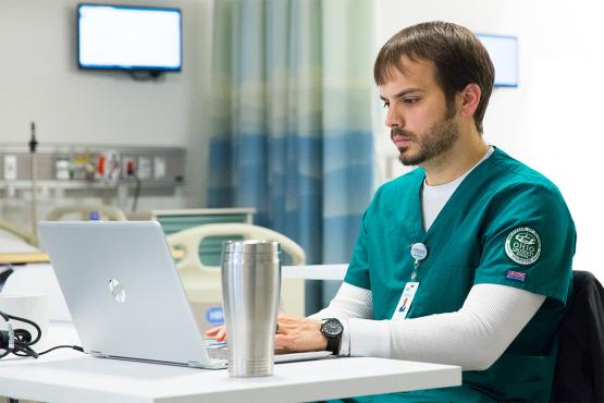  An Ohio University nurse practitioner student working at their laptop 