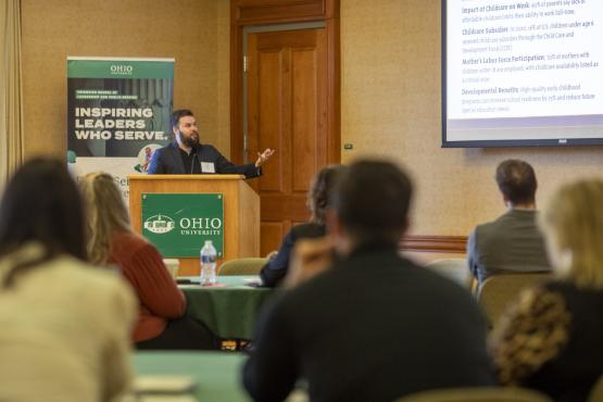 A speaker gives a presentation at the GIS Symposium