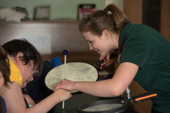  An OHIO music therapist engaging a patient in therapeutic drumming using a frame drum. 