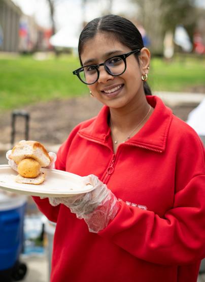 An OHIO student shows off an international food item at the International Street Fair