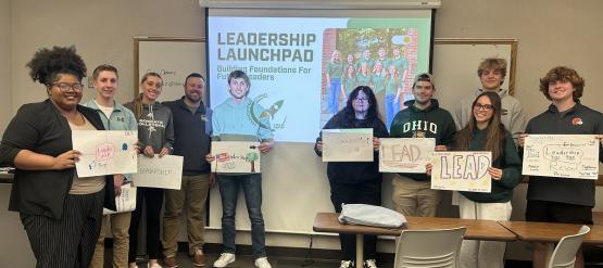  Members of Leadership Launchpad holds up signs about Leading 