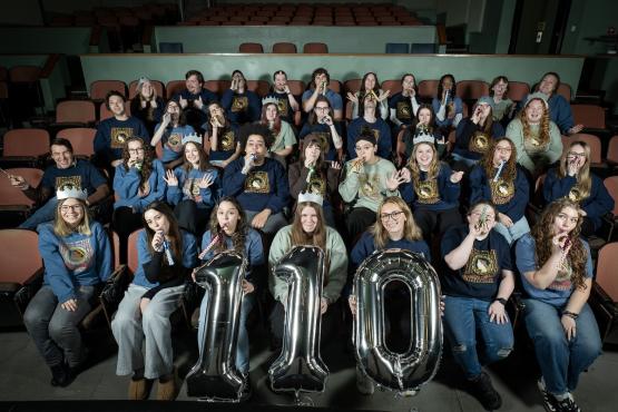  Staff members are shown in the seats at the Athena Cinema holding the numbers 1-1-0 and wearing party hats and blowing party horns 