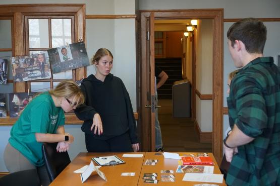  OHIO  students stand around a table filled with clues  and talk together to solve the mystery 