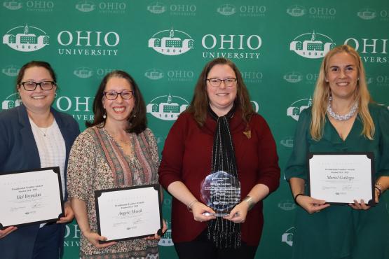  Mel Brandau, Angela, Hosek, Sabrina Curran and Murial Gallego hold their awards in front  of an Ohio University media wall 