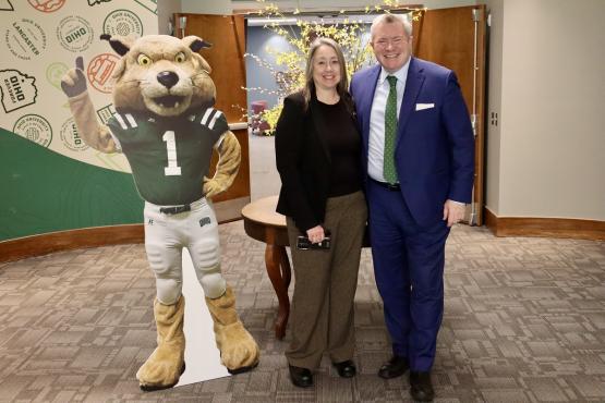 Two leaders at the STEM Discovery Day event pose with the cutout image of Rufus