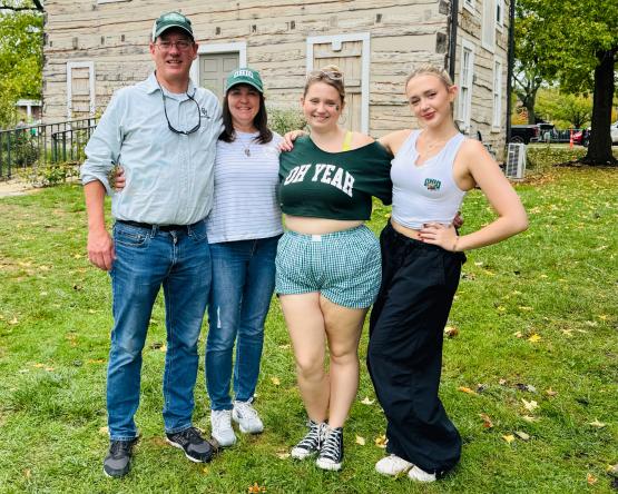  a father, mother and two daughters pose wearing ohio university attire 