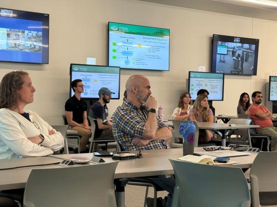 Individuals sit and listen to a presentation at the ITDI ceremony in May 2025