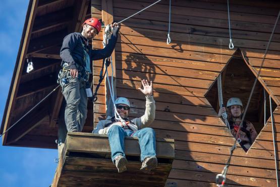 Three individuals are shown getting ready to zip line.