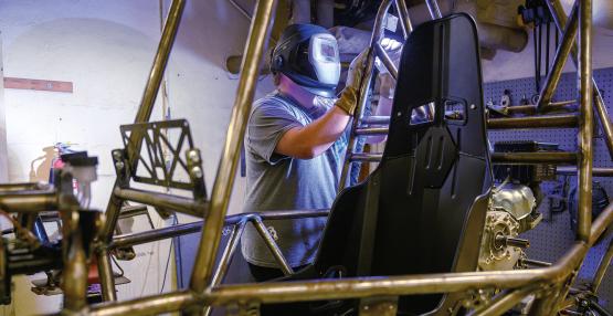 a student welds the frame of what will become an off-road vehicle