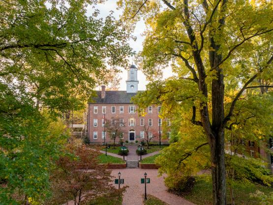 Cutler Hall is surrounded by colorful trees on the College Green on a day in fall
