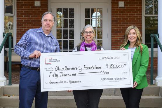 Matthew Roberts, Jennifer Bowman and Melissa Clark hold a poster of a check for $50,000