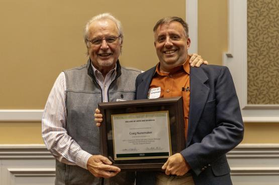 John Kopchick and Craig Nunemaker hold the award
