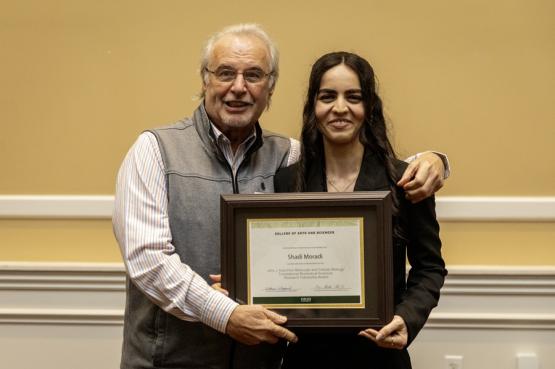 John Kopchick and Shadi Moradi hold the award