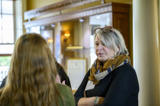 Three individuals talk together during the luncheon event