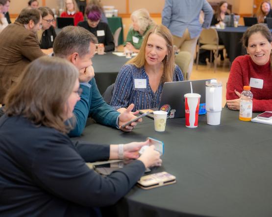 OHIO faculty and staff talk with one another while sitting at tables at the T1 Summit