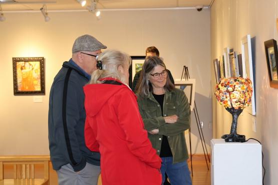 Three people look at a hand-crafted lamp in the art gallery at OHIO Chillicothe