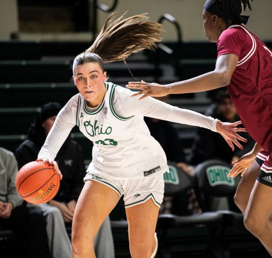 An OHIO Women's Basketball Player dribbles the ball past a defender during a game in the Convocation Center