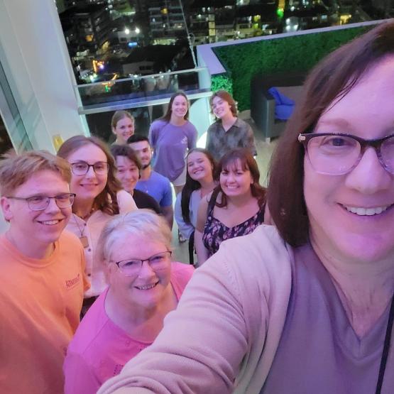 OHIO students and faculty stand together in a building with a city skyline shown in the windows behind them