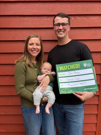 Student Jonathan Peters holds Match Day sign with family