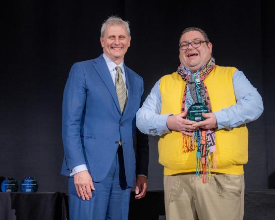 Provost Don Leo and Sam Kizer stand together while Kizer holds an award