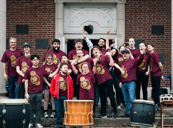 The Ohio U Percussion club standing together with large taiko drums in front of them.